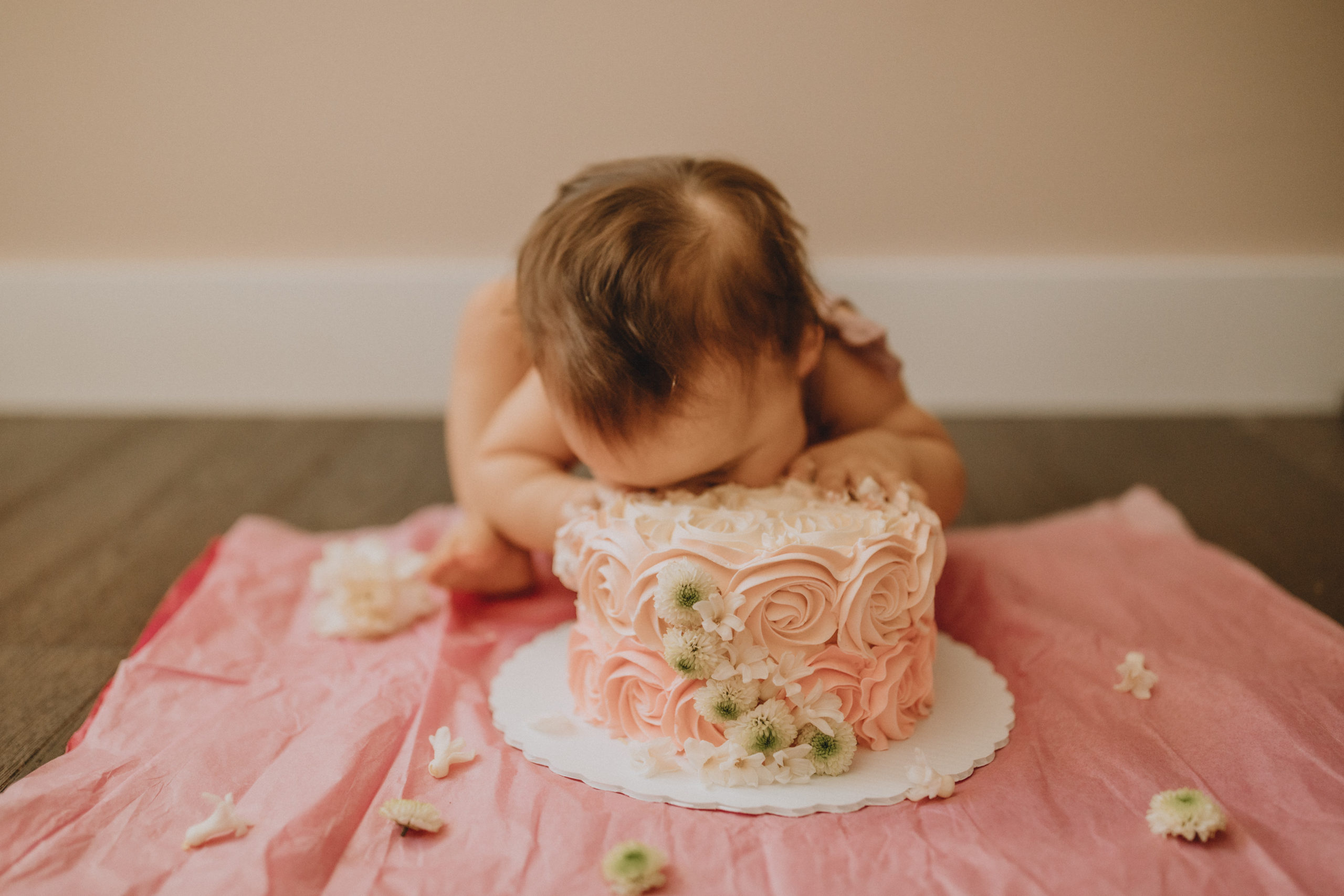 baby shoving her face in a cake